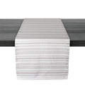 White and gray striped table runner with red accent lines draped across dark surface.