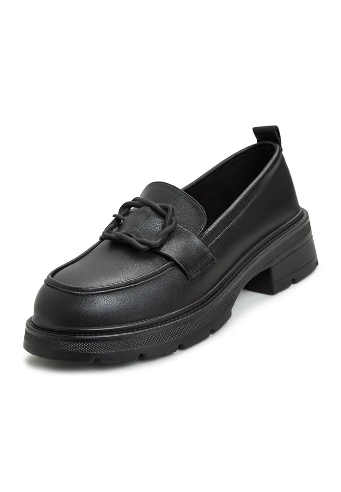 A stylish black platform loafers paired with a traditional sari, representing trendy women's fashion footwear with a touch of sophistication.