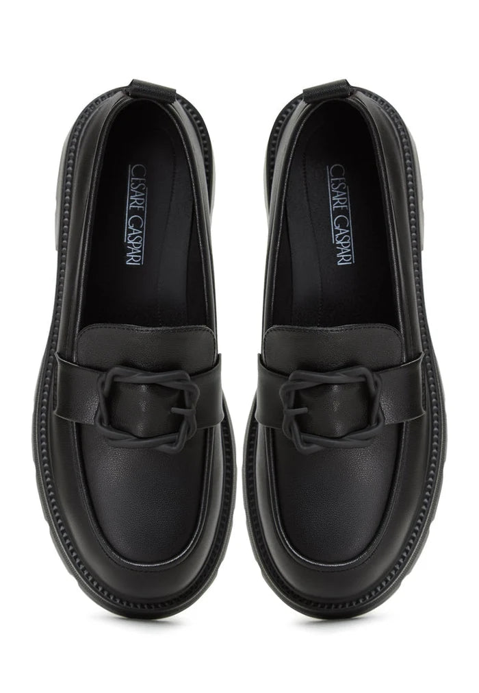 A stylish black platform loafers worn with a traditional Indian sari, making for fashionable women's footwear.