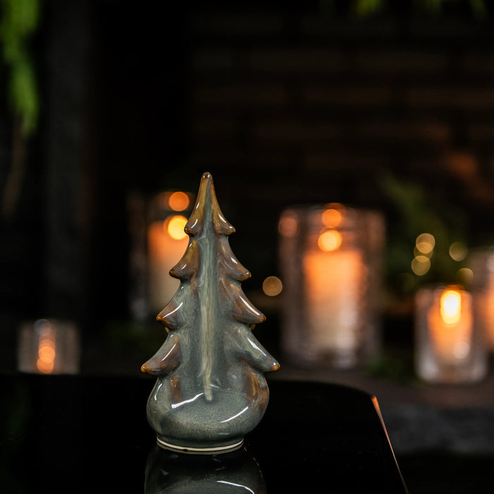 Moss-green ceramic evergreen tree figurine with glazed finish and pointed branches.