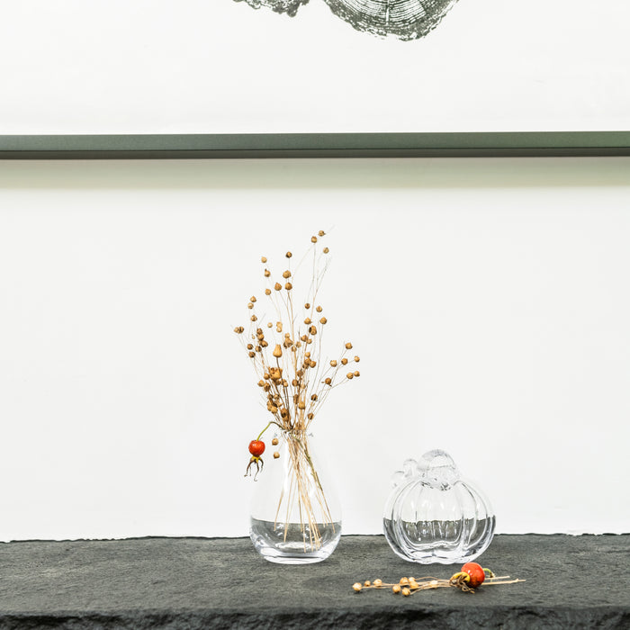 Glass vase with dried golden berries and a single orange pumpkin ornament, accompanied by a clear glass gift box.
