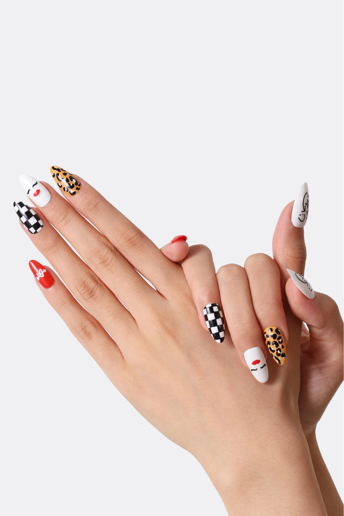 Press-on nails with retro rock 'n' roll designs: checkerboard, leopard print, and a red lipstick face.