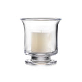 Clear glass hurricane vase with pedestal base holding a cream-colored pillar candle.