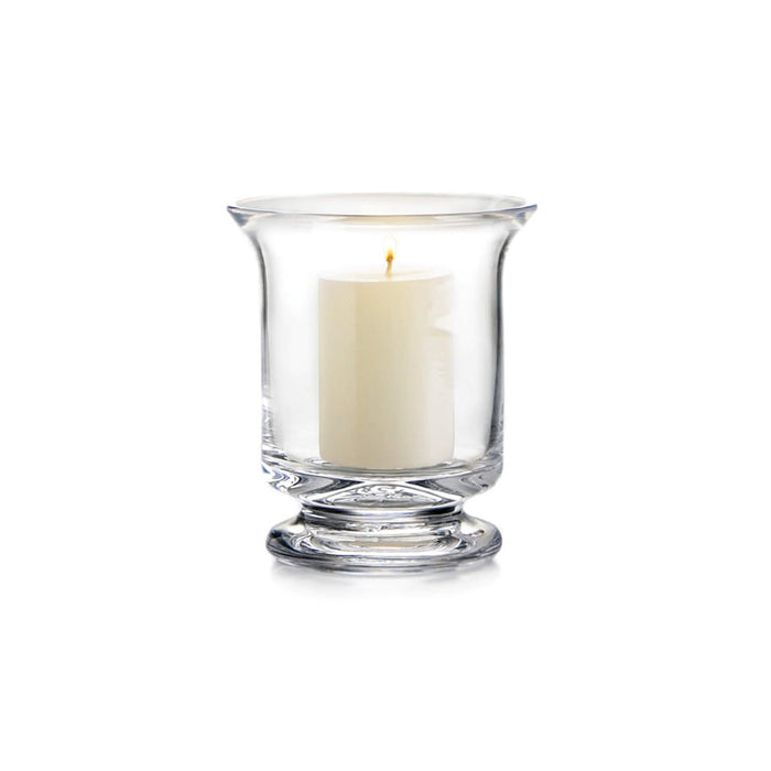Clear glass hurricane candle holder with cream colored pillar candle inside.
