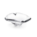 Clear glass dish with heart-shaped top and black branch-like handles on sides.