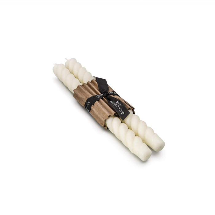 Two cream-colored tapered candles with rope-wrapped bases bound together with a black label band.