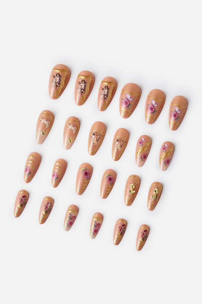 Almond press-on nails with rose gold rococo designs featuring cherubs, roses, and butterflies.