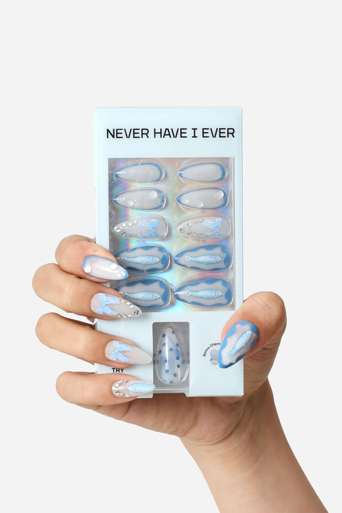 Almond press-on nails with blue sardine and wave designs, featuring rhinestones and blue bows.