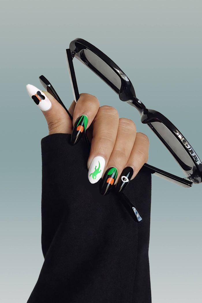 Ghost and Shark press-on nails by Lorien Stern: green lizard, orange mushrooms, black eye design.