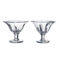 Two clear glass dessert bowls with pedestal bases and flared rims.