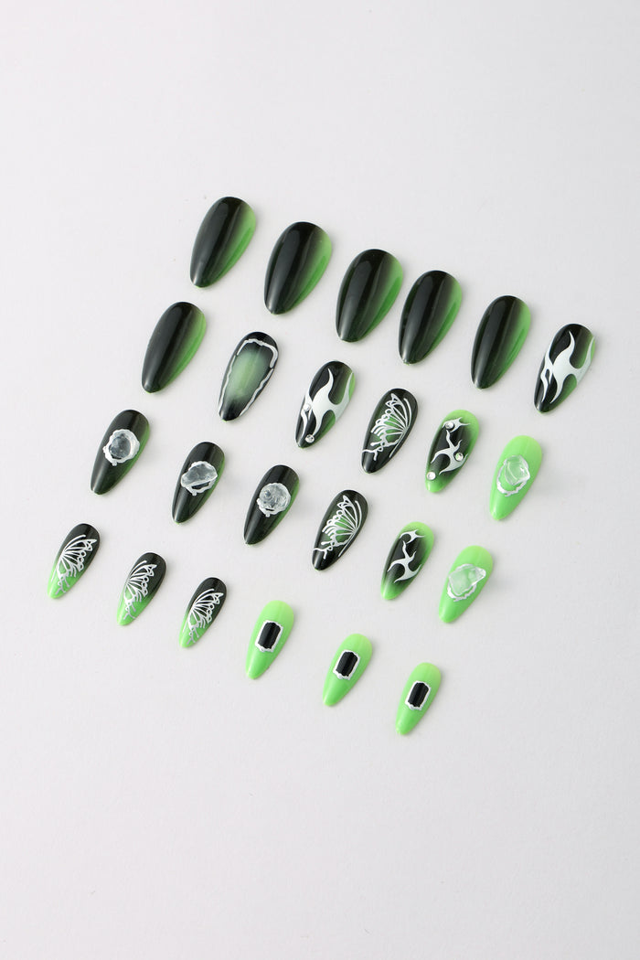 SHE'S A BRAT press-on nails with green and black ombre, flame, butterfly, and gem designs.