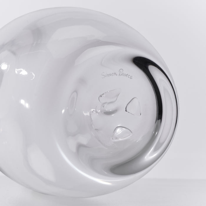 White ceramic carafe with black handle and leaf design etched on the body, shown from above.