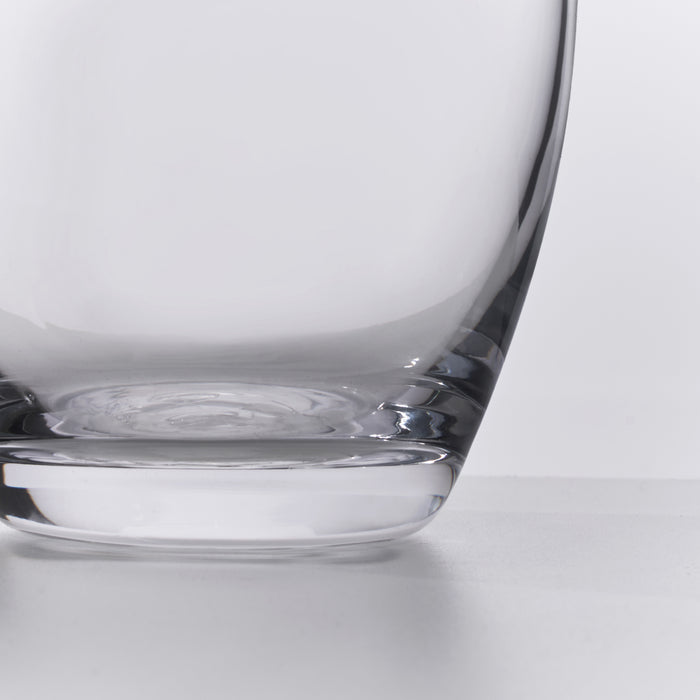 Clear glass carafe with curved walls and a wide base, shown from side angle against white background.