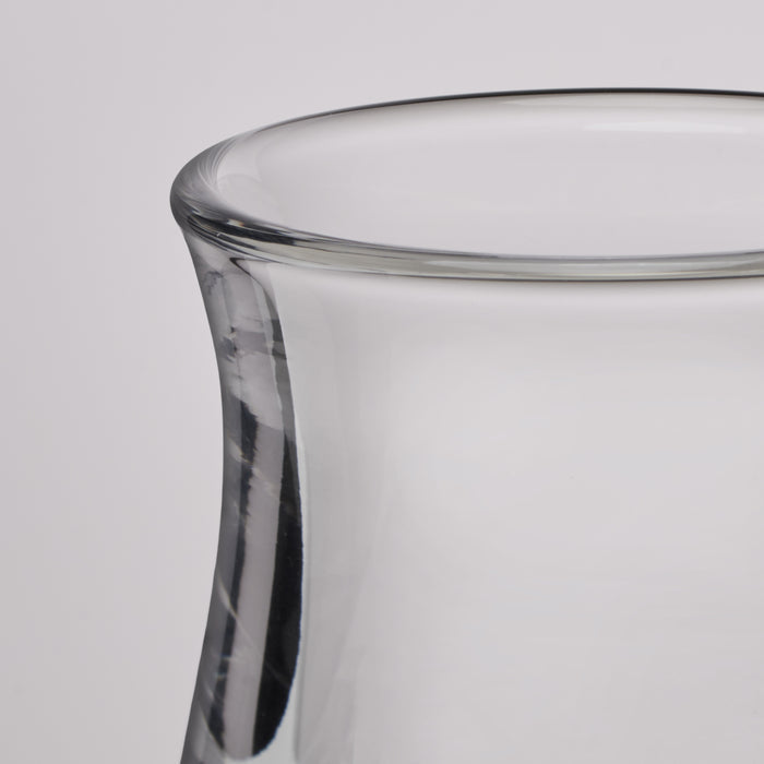 Close-up of a clear glass vase with a flared rim and smooth cylindrical body on a light gray background.