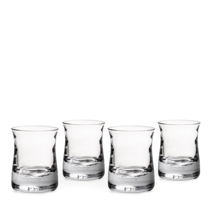 Set of four clear glass whiskey tumblers with weighted bases and tapered sides.
