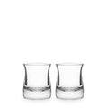 Two clear glass whiskey glasses with curved sides and weighted bases, each partially filled with clear liquid.