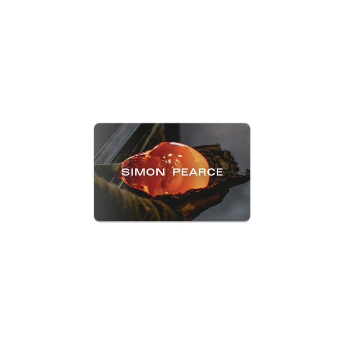 Simon Pearce digital gift card with glowing orange glass vessel in hands.