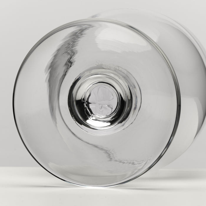 A clear glass bowl photographed from the bottom on a light gray studio background.