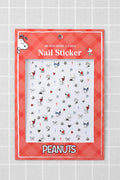 Peanuts nail stickers with Snoopy and Woodstock designs on a red checkered background.