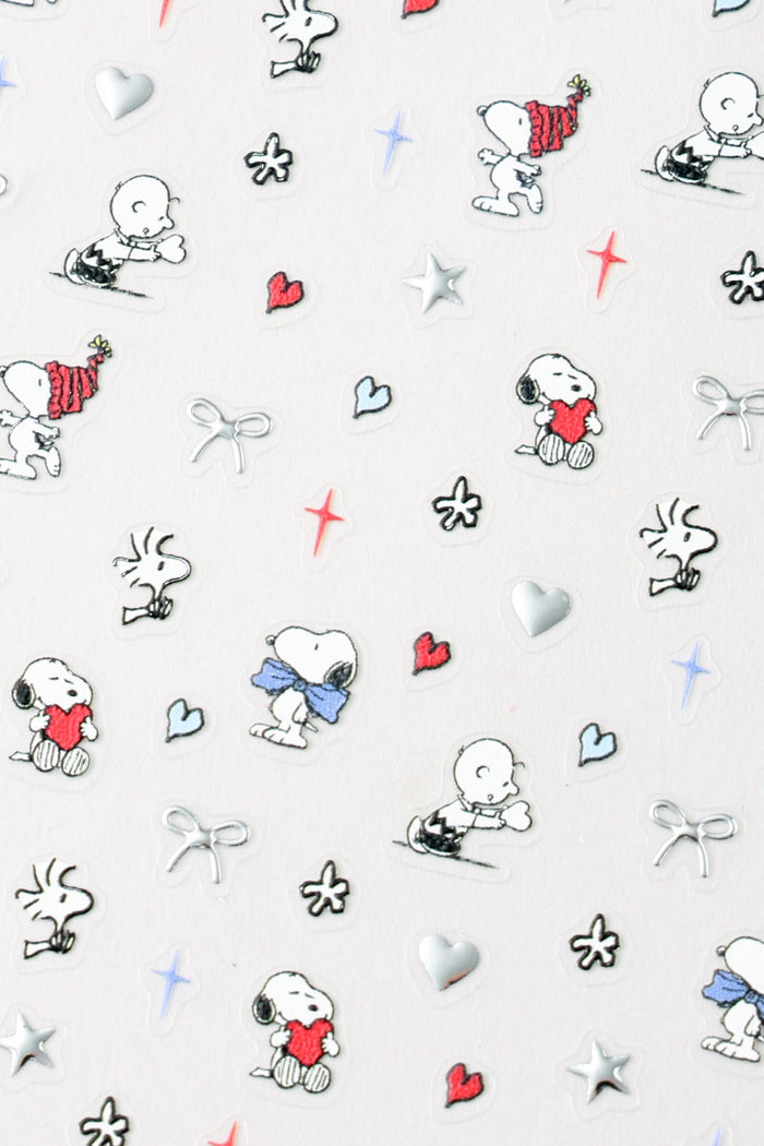 Peanuts nail stickers featuring Snoopy and Charlie Brown in various playful poses, with hearts and stars.