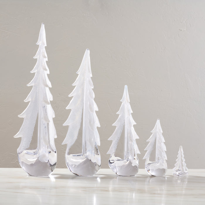 Five white frosted glass evergreen tree figurines in graduated sizes with snow-like coating on branches.