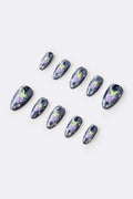 Sparkly dark blue press-on nails with green alien creatures and purple polka-dot mushrooms, set on a white background.