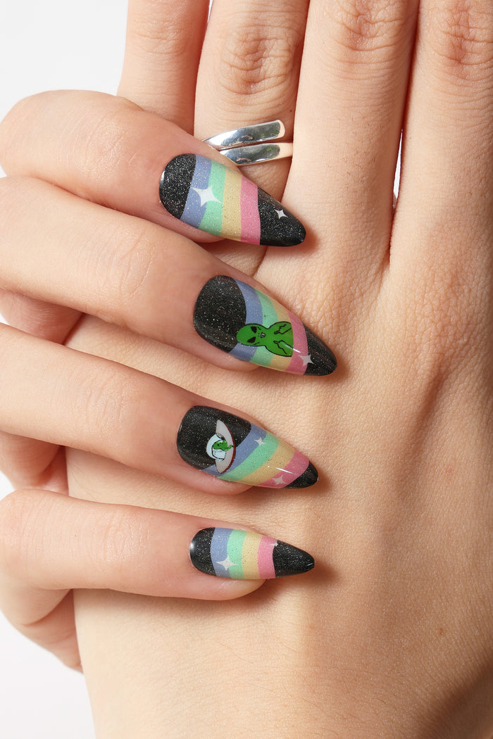 Ripndip stiletto press-on nails with black glitter and pastel rainbow design, featuring an alien and eye.