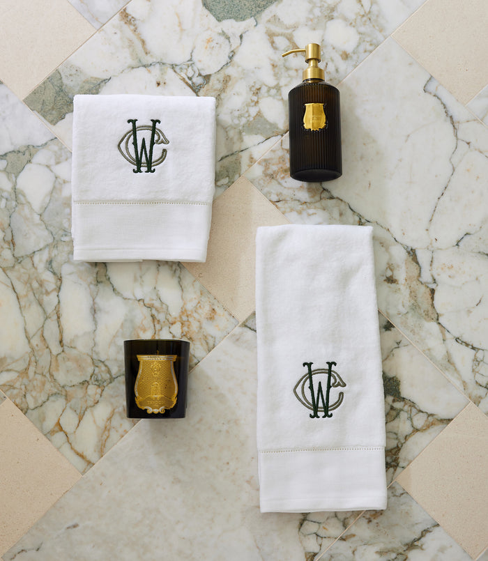 Special Occasion Towel Gift Set in White with monogram design, black soap dispenser, and gold candle on a marble surface