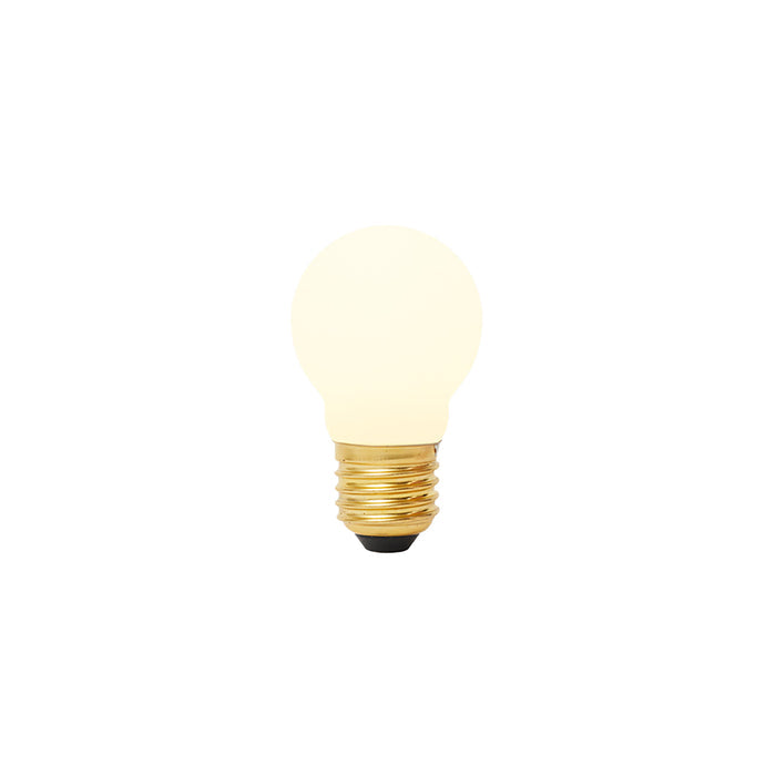 Matte porcelain spherical LED bulb with brass threaded base and black contact point, glowing warm white.