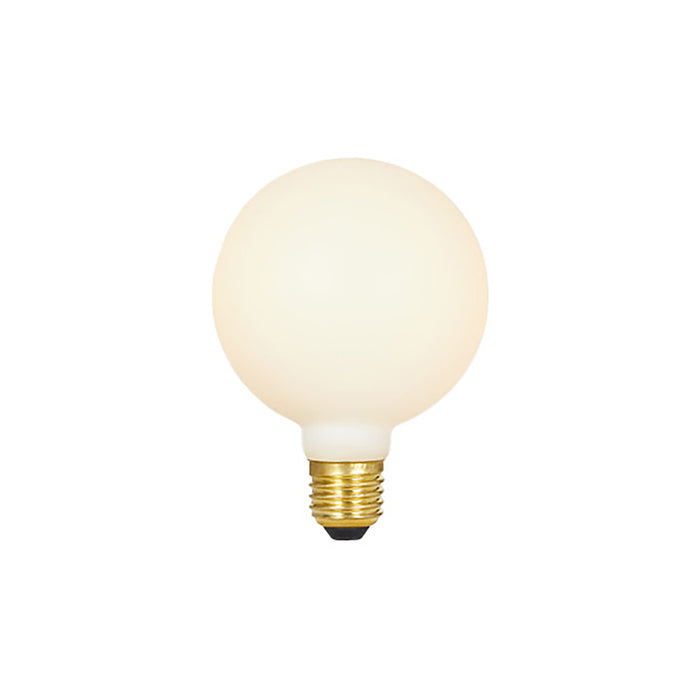 Matte cream-colored spherical LED bulb with brass screw base and black contact point.