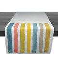 Linen table runner with vertical stripes in teal, coral, yellow, and beige on white background.
