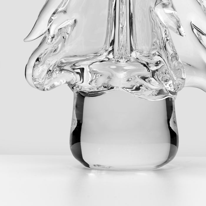 Clear glass vessel with organic, curved top and cylindrical white base containing liquid.
