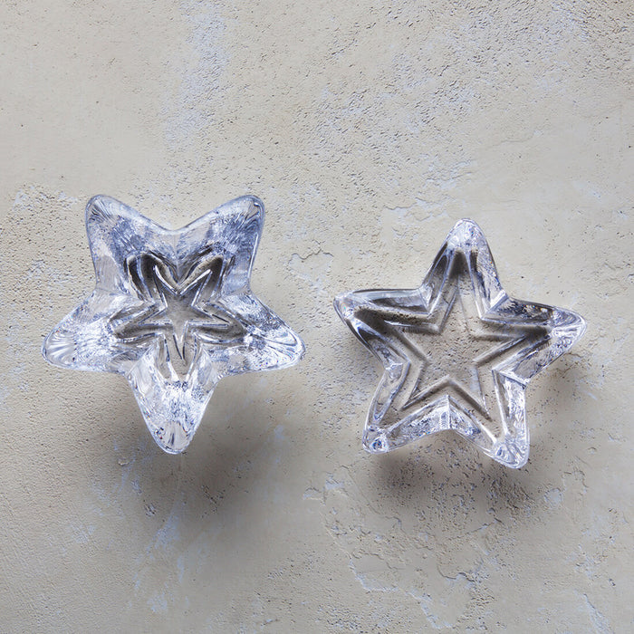 Small clear glass star-shaped paperweight with textured surface, shown from two angles.