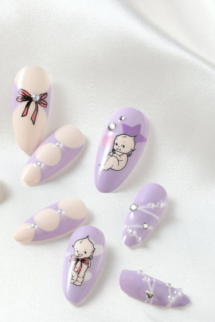 Purple press-on nails with Kewpie characters and pearl accents.