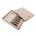 Six steak knives with serrated blades and rosewood handles displayed in an open wooden box.