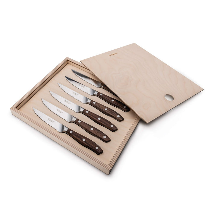 Six steak knives with serrated blades and rosewood handles displayed in an open wooden box.