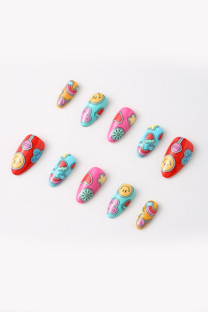 Press-on nails featuring colorful designs like smiley faces, strawberries, and rainbows.
