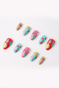 Press-on nails featuring colorful designs like smiley faces, strawberries, and rainbows.