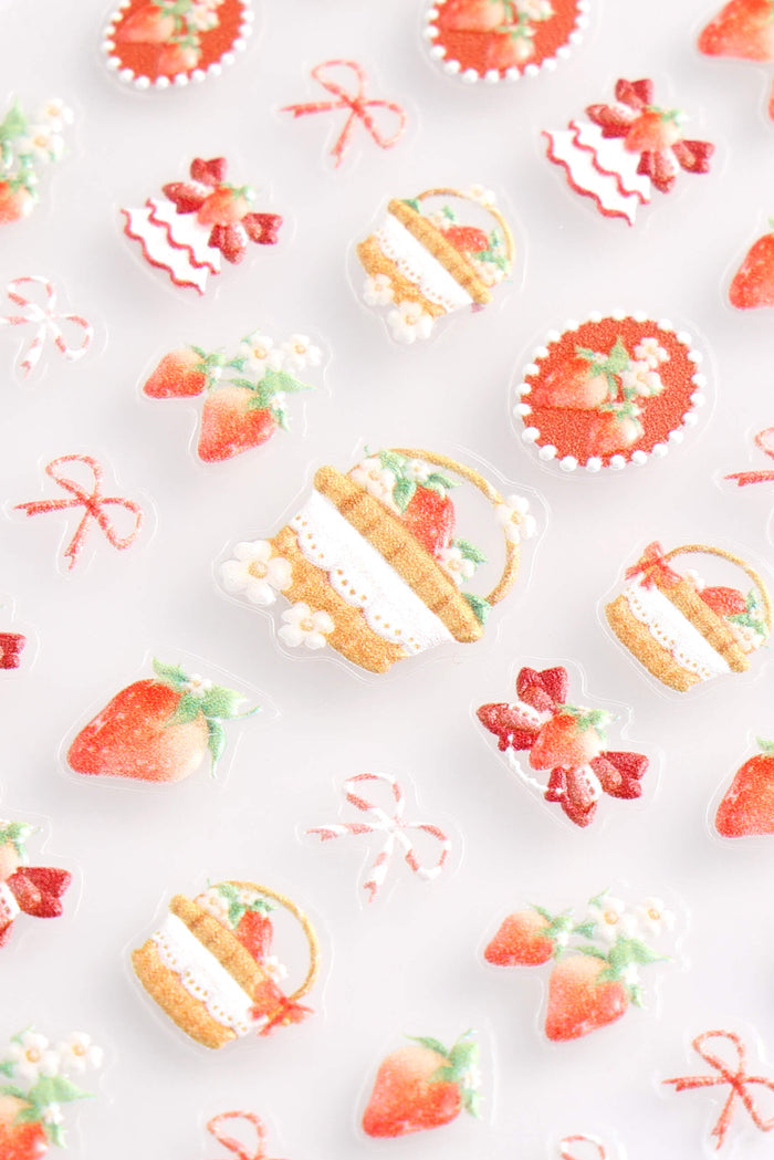 Sheet of "Strawberries N Creme" nail stickers featuring various designs like strawberries, floral arrangements, and ribbons.