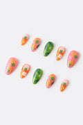 Press-on nails featuring strawberry and leaf designs in pink, green, and orange.