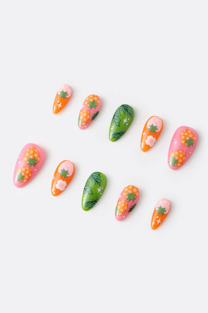 Press-on nails featuring strawberry and leaf designs in pink, green, and orange.
