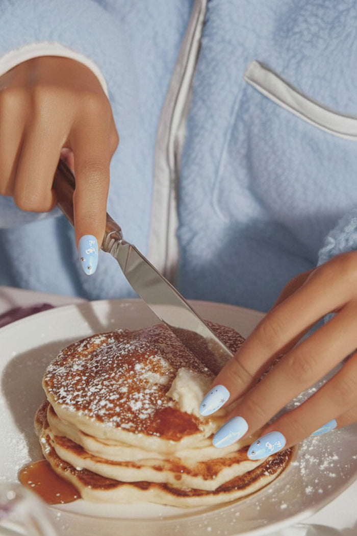 Light blue almond press-ons with Snoopy and stars, cutting into pancakes.
