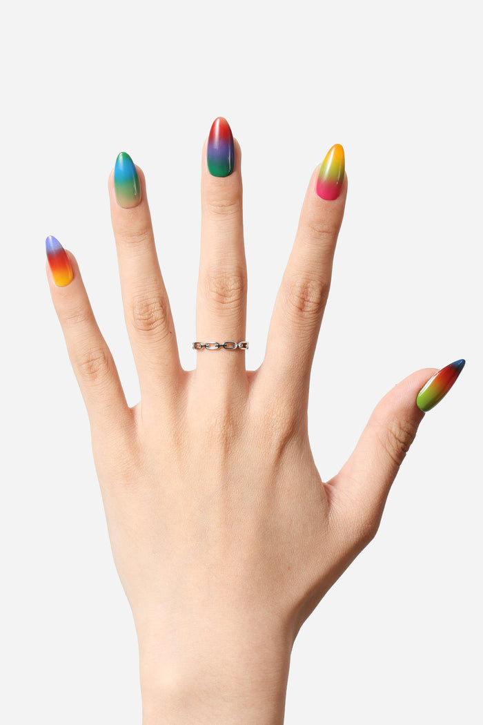 Almond press-on nails with vibrant sunset gradient: blue, green, yellow, orange, pink, red.