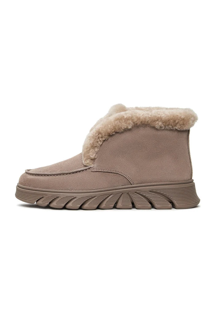 A stylish pair of taupe shearling-lined ankle boots, known as the Adriana Brown Boots, perfect for keeping your feet warm and fashionable this winter.