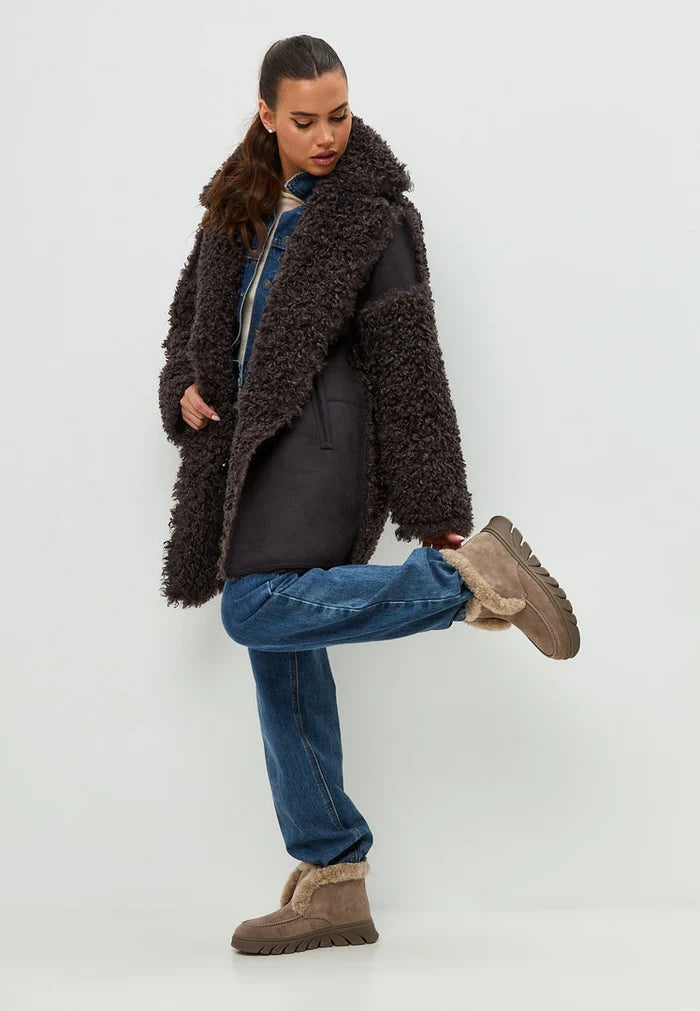 A stylish pair of taupe shearling-lined ankle boots, also known as the Adriana brown boots, perfect for keeping your feet warm and fashionable in chilly weather.