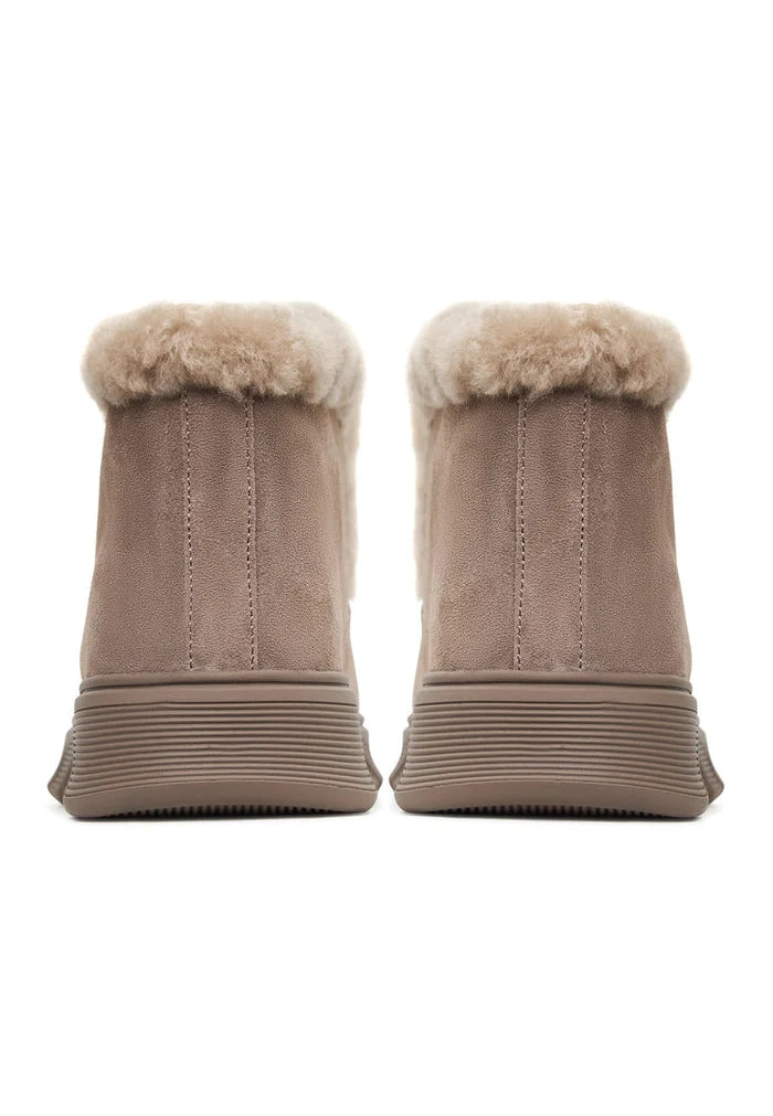 A stylish pair of women's taupe shearling-lined ankle boots, featuring the Adriana brown design ideal for cold weather with ultimate comfort and style.