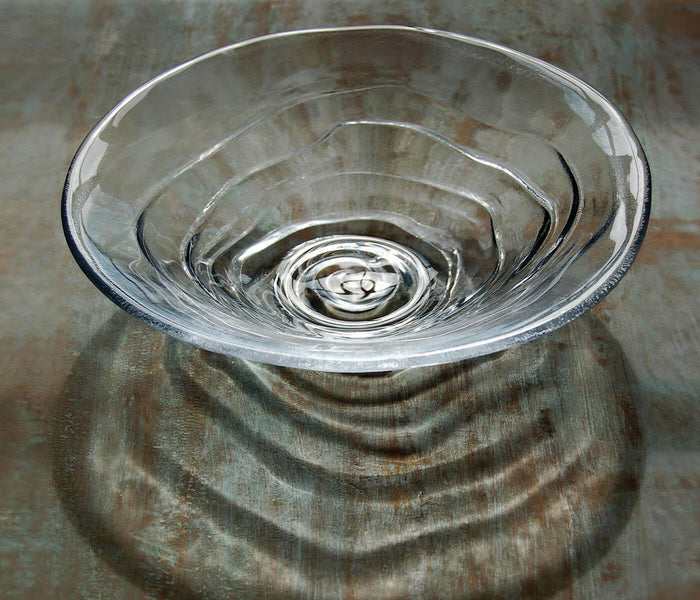 Clear glass bowl with concentric ripple pattern and water droplet detail inside.
