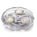 Silver tray holding three cream-colored tealight candles in clear cups arranged in a triangular pattern.