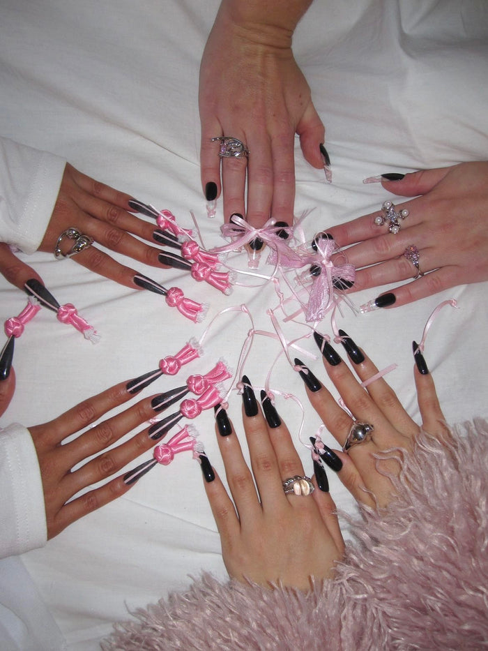 Dawang Valentine's Bundle Collection: four hands with long black stiletto press-on nails adorned with pink bows and ribbons.