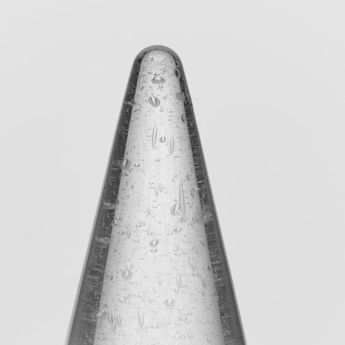 Tall conical candle with white and dark gray coloring and textured surface details.